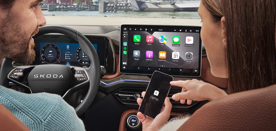 A couple connecting a phone to a Skoda via Smartlink