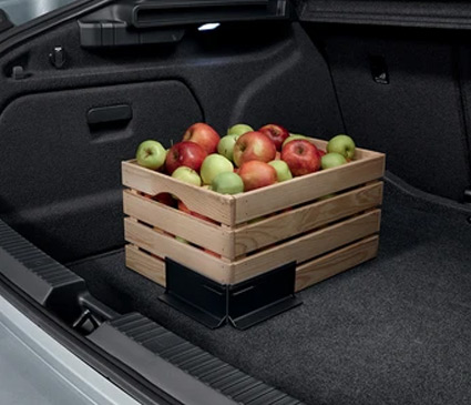 A box of food held in place by cargo elements in the boot of a car