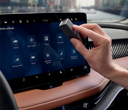 hand cleaning the display screen in a car
